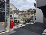 ロイジェント西新井 自転車置き場とバイク駐輪スペースがある共用部の様子