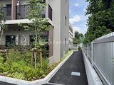 ロイジェント西新井 緑の植栽が映える共用通路と建物外観