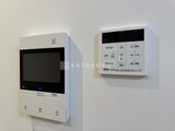 ロイジェント西新井 壁に取り付けられた給湯器と浴室リモコンパネル