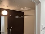 ロイジェント西新井 ダークブラウンのアクセントパネルと照明が落ち着いた浴室空間