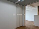 ロイジェント西新井 モダンな建具の引き戸付き、明るい洋室への入口の様子