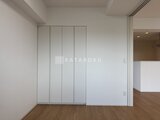 ロイジェント西新井 白を基調とした壁面に大容量のクローゼットが備わった洋室空間