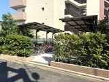 クレアティフ三軒茶屋 緑に囲まれた自転車置き場とパーゴラのある敷地