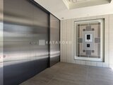 クレアティフ三軒茶屋 モダンなタイル貼りの共用廊下とステンレス製エレベーター扉