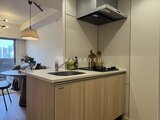 クレアティフ三軒茶屋 木目調キャビネットと白天板のアイランドキッチン、ペンダント照