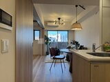 クレアティフ三軒茶屋 キッチンから見たリビングダイニング、都心の景色を望む開放的な