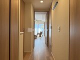 クレアティフ三軒茶屋 木目調のドアが並ぶ明るい廊下からリビングへ続く通路