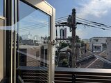 クレアティフ三軒茶屋 大きな窓から都市風景を望むバルコニーの眺め