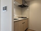クレアティフ三軒茶屋 木目調キャビネットと鏡張りのすっきりとしたキッチン