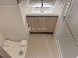 クレアティフ三軒茶屋 ウッド調キャビネットの洗面台がある清潔感のあるバスルーム