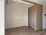クレアティフ三軒茶屋 木目調のクローゼット扉と落ち着いた色合いのリビングダイニング