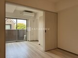 クレアティフ三軒茶屋 明るいフローリングのリビングダイニングと洋室への引き戸