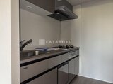 クレアティフ三軒茶屋 モダンな色合いのシステムキッチンと調理スペースの様子