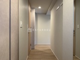 ラグゼナ北千住2 明るい照明が灯る廊下と複数の居室入口