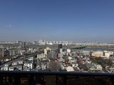 ラグゼナ北千住2 高層階からの開放的な眺望で、街並みと河川が広がる様子