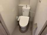 ラグゼナ北千住2 温水洗浄便座付きトイレと上部収納を備えた清潔感のあるトイレ室