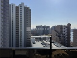ラグゼナ北千住2 高層階からの眺めで複数の住宅棟と駐車場が見える風景