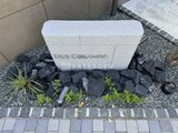ドゥーエ王子神谷 玄関前の落ち着いた色合いの石積みと植栽がある共用部