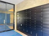 ドゥーエ王子神谷 黒いメールボックスが整然と並ぶ共用部と奥のエントランスホール