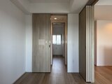 ドゥーエ王子神谷 木目調のドアと建具が調和した廊下から洗面室へと続く空間