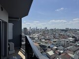 ドゥーエ王子神谷 バルコニーから見た開放的な街並みと晴れた空