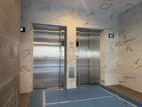 ステラテラス エレベーターホール、大理石調パネルとステンレス扉の落ち着いた