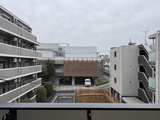 リビオメゾン湯島 複数の建物に囲まれた落ち着いた雰囲気の共有スペースと駐車場