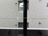 リビオメゾン湯島 白いタイル張りの建物外壁とシンプルなアルミサッシの玄関ドア