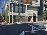 コージーコート谷中 日中の陽光が当たるモダンな建物のエントランス前面