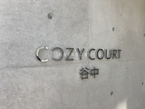 コージーコート谷中 コンクリート調の壁面に立体文字で表記された建物名のサイン