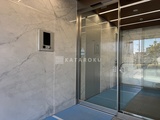 コージーコート谷中 モダンなデザインのエレベーターホール、大理石調壁とガラス扉が