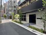 リビオメゾン浅草雷門 緑の植栽と石張りの外壁が調和した、モダンなエントランスアプロ