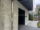 リビオメゾン浅草雷門 石貼りの外壁と黒いドアが特徴的なモダンなエントランスの様子