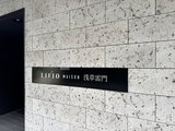 リビオメゾン浅草雷門 コンクリート壁に設置された黒い建物サイン