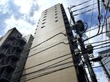 リビオメゾン浅草雷門 街路から見た建物の落ち着いた外観と青空