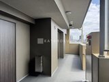 リビオメゾン浅草雷門 黒いアクセント壁が特徴的な落ち着いた共用廊下の様子