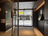 リビオメゾン浅草雷門 木調の柱と間接照明で落ち着いた雰囲気のエントランスホール