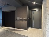 リビオメゾン浅草雷門 モダンな共用部のエレベーターホールと落ち着いた色合いの壁面