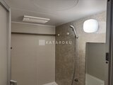 リビオメゾン浅草雷門 落ち着いた色合いの浴室、シャワーヘッドと換気窓が備わる空間