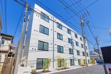 アグライア新宿横寺町 晴天の下で見た白を基調とした建物の外観
