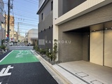 ライブカーサ文京千石プレミア 駐車場から見た建物エントランスと前面道路の様子