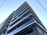 ライブカーサ文京千石プレミア 下から見上げた建物の外観、モダンなバルコニーと整然とした窓配