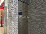 ライブカーサ文京千石プレミア モダンな配色のエレベーターホール、グレーのタイル壁が落ち着い