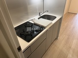 ダフィット錦糸町 ガスコンロと水切りかごが設置された白を基調としたコンパクトキ