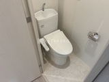 ダフィット錦糸町 温白色系でまとめたトイレ空間、手洗い付きの清潔感のある室内