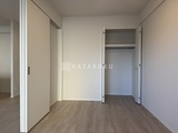 ダフィット錦糸町 明るい色合いの壁と木目調フローリングの落ち着いたベッドルーム
