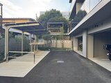 プラウドフラット西蒲田 開放的なアプローチと駐車スペースから見た建物エントランス