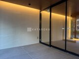 プラウドフラット西蒲田 モダンな黒枠ガラスドアと落ち着いた配色のエントランスホール