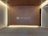 プラウドフラット西蒲田 木調パネルの壁と間接照明が落ち着いた印象のエントランスホール