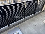 プラウドフラット西蒲田 モダンな黒いルーバーフェンスとコンクリート床の駐車スペース